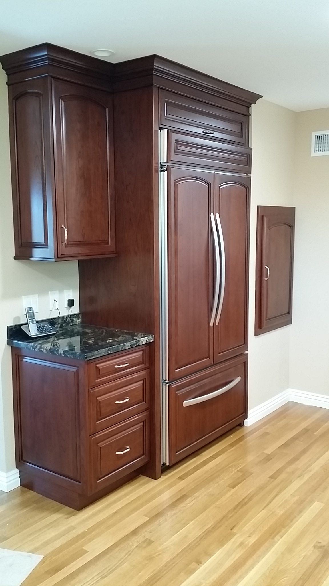 Cherry cabinets with a paneled refrigerator built in to match.